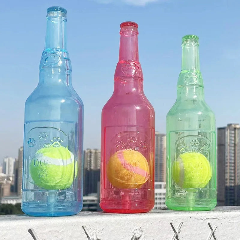 Bouteille bleu, rouge et vert avec une balle de da s pour les chiens qui aiment jouer. Les bouteilles sont devant une grande ville. Image produit Boutiquechein