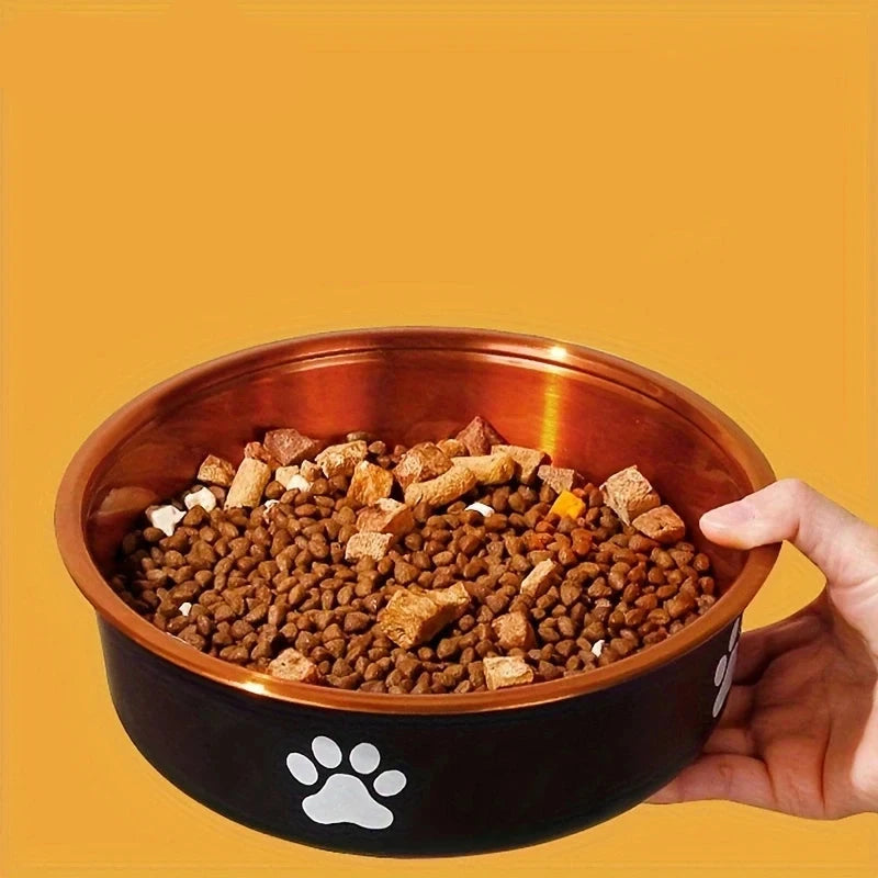 Croquette pour chien dans une gamelle de couleur bronze et noir avec patte blanche. Le produit est tenu par une main blanche. Image produit Boutiquechien