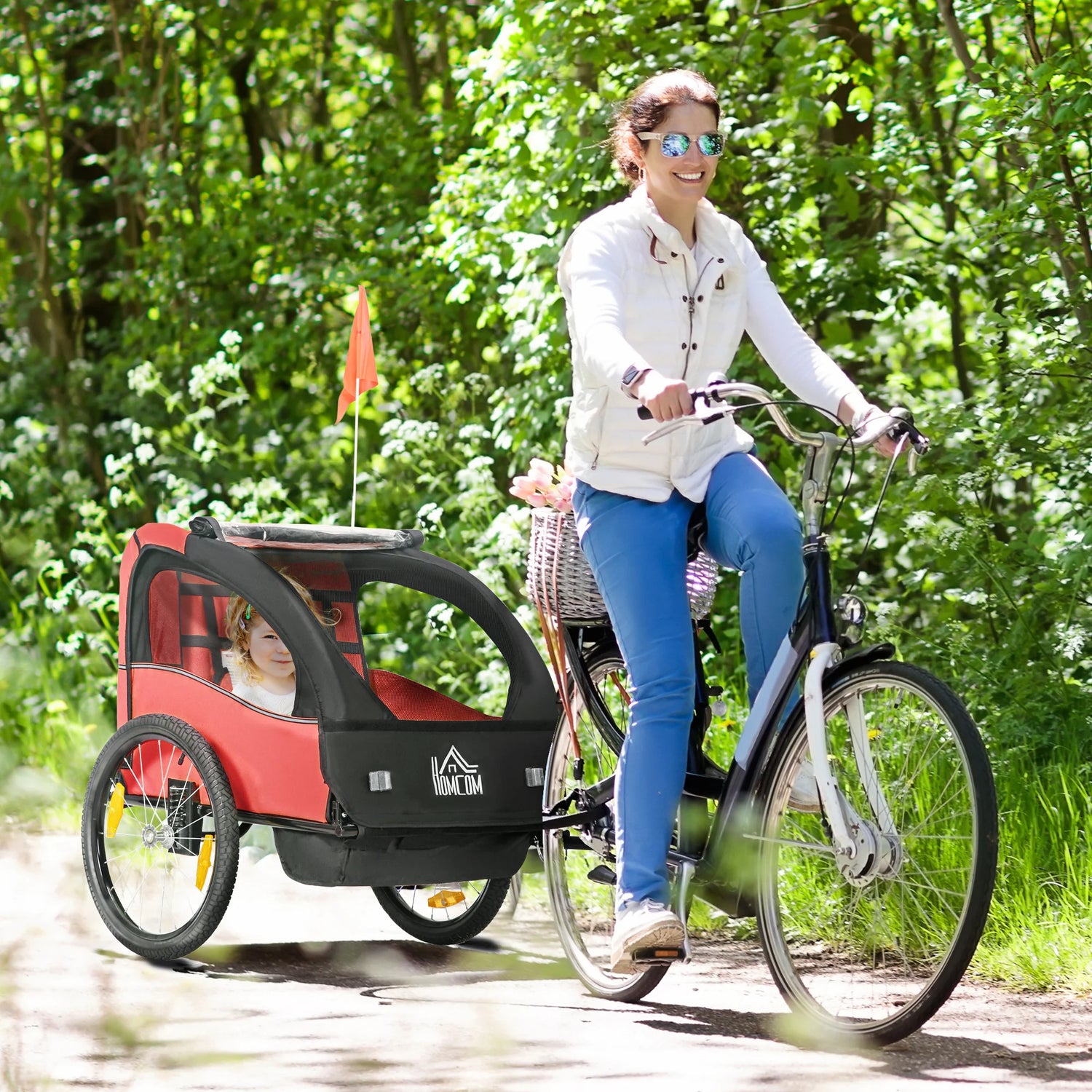 femme à vélo habille avec un jean bleu et une veste blanche. La remorque vélo est de couleur rouge et noir. Image prdoduit Boutiquechien
