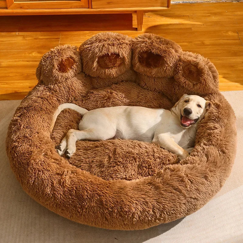 panier chien xl en forme de patte brun posé dans un salon avec un sol en bois et un meuble en bois. Image produit Boutiquechien