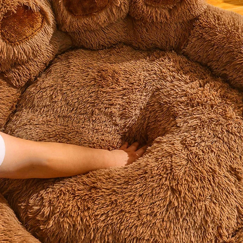 Panier chien xl en forme de pattes se faisant touché par une mains pour montrer la douceux du panier chien xl en forme de pattes. Image produit Boutiquechien