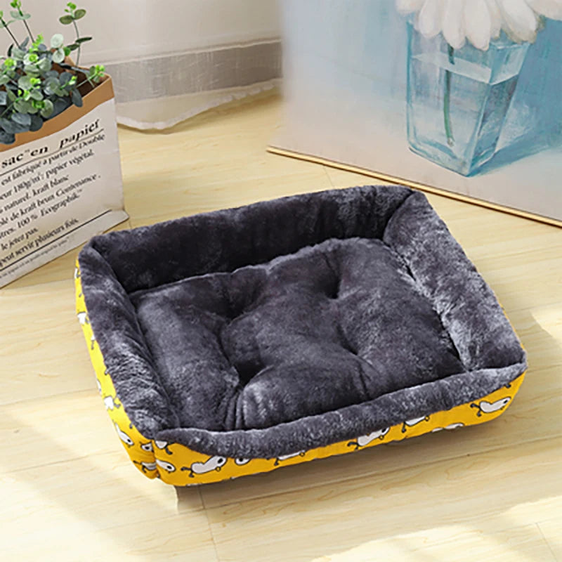 Panier pour chien avec motif canard dessus pour chien de toutes les tailles. Le panier est posé par terre à côté d'un tableau et d'une plante verte pour boutiquechien