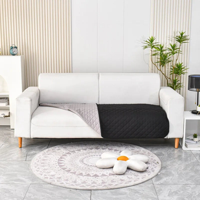 Tapis chien noir canapé lavable protégeant un canapé blanc. le canapé blanc est dans un salon de couleur blanc avec sur le côté une table basse. image produit Boutiquechien