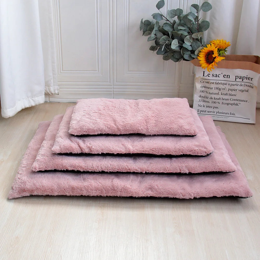 Tapis doux pour chien de couleur rose posé les uns sur les autres. En fond il y a un mur blanc et une plante verte. Image produit Boutiquechien
