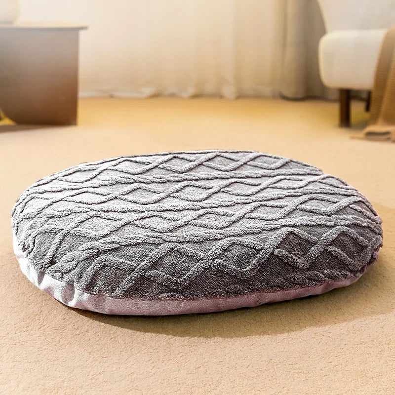 tapis doux pour chien de couleur gris posé sur un sol claire avec en fond un canapé blanc et une table basse en bois. Image produit Boutiquechien