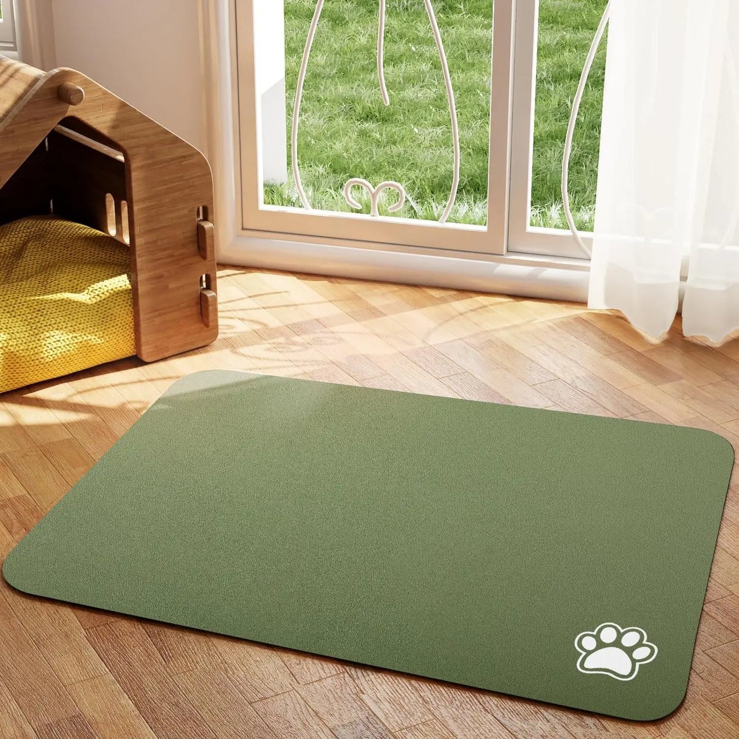 Tapis chien de couleur kaki avec une patte de couleur blanche sur le tapis pour gamelle de chien. Le tapis à gamelle pour chien est posé dans un salon avec sur le côté une niche en bois. Image produit Boutiquechien