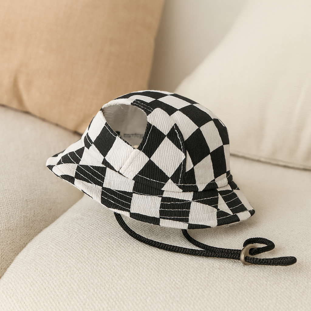 Bob à carreaux pour chien de couleur blanc et noir sur un canapé blanc de boutiquechien