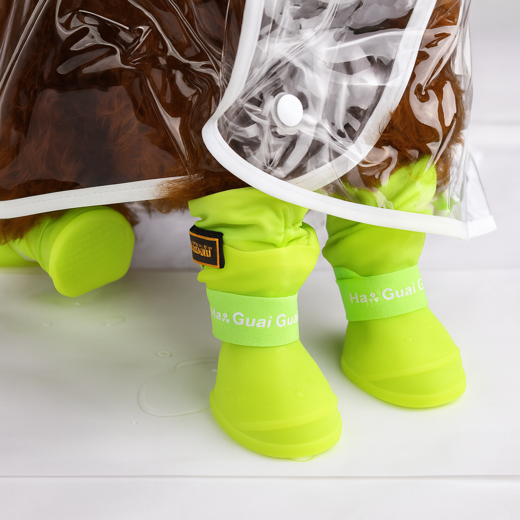 Chien de couleur brun portant une parka transparente et des bottes vert fluo pour chien assis. Image produit Boutiquechien
