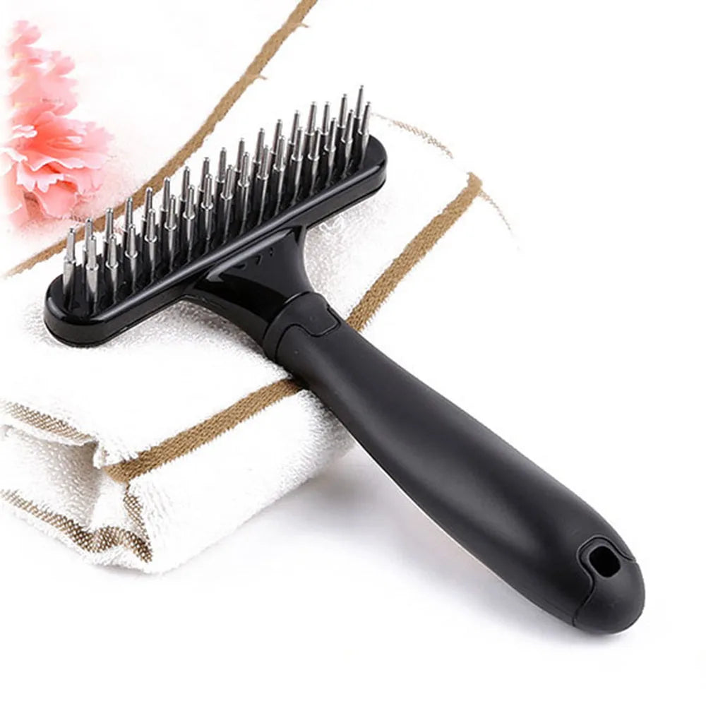 brosse pour chien de couleur noir démêlante avec des picots pour démêler. Le produit est mis en valeur sur une serviette blanche avec des traits brun. Image produit Boutiquechien