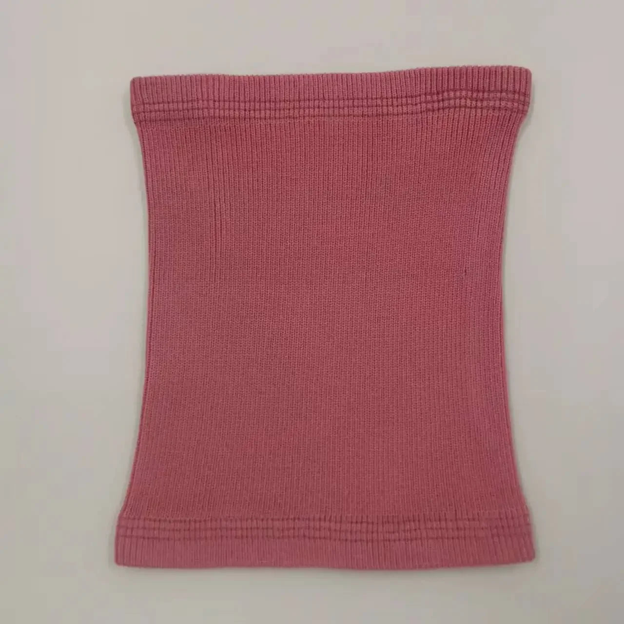 Cache cou et oreilles pour les chiens. le cache cou est de couleur rose et il est posé dans un couleur gris. Image produit Boutiquechien