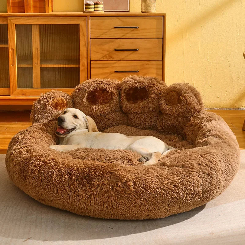 Panier chien xl brun en forme de patte posé dans un salon de couleur claire en bois. Dans le panier chien xl il y a un grand chien blanc. Image produit Boutiquechien