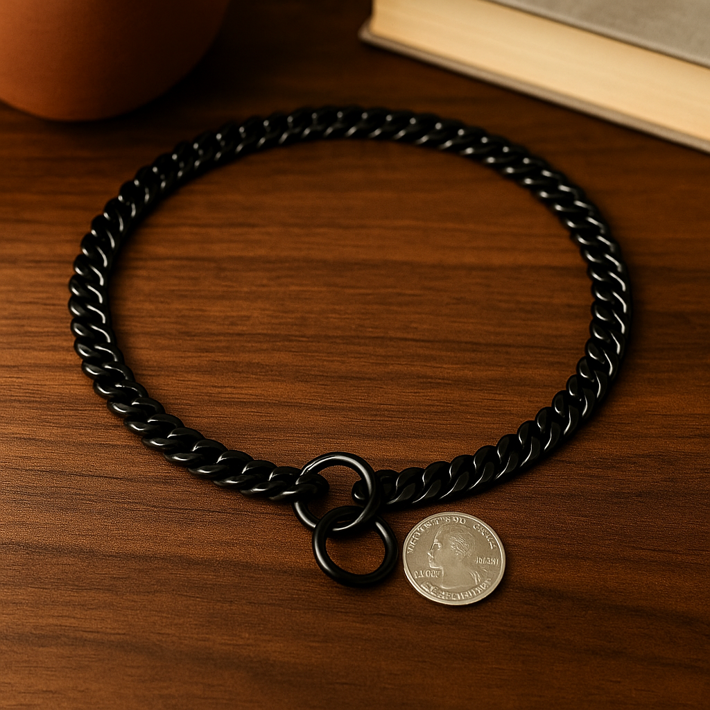 collier chien de couleur noir posé sur une table de couleur foncé en bois. Le collier est comparé avec une pièce pour voir la taille. Image produit Boutiquechien