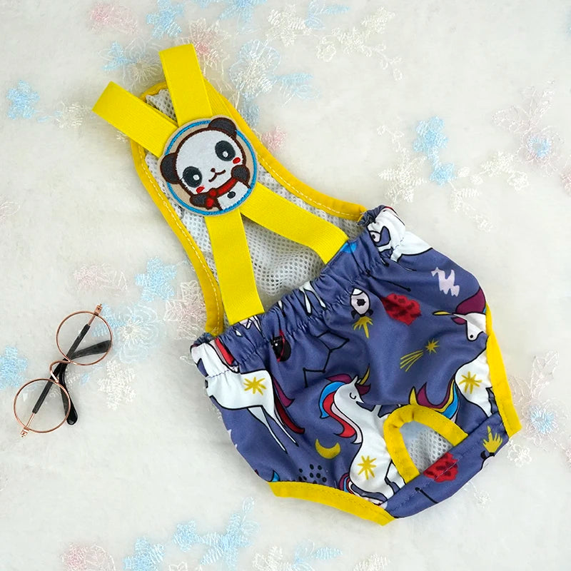 Couche à bretelle pour chien de couleur bleu avec des formes de licorne. Le produit est posé dans un fond blanc. Image produit Boutiquechien
