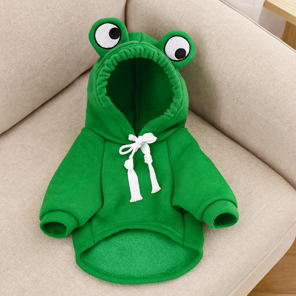Déguisement en forme de grenouille de couleur verte. Le produit est posé sur un canapé de couleur gris. Image produit Boutiquechien