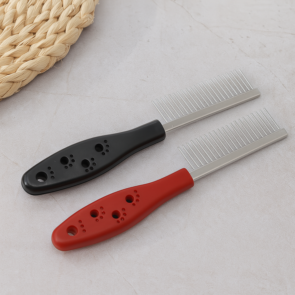 peigne pour chien de couleur noir et rouge posé sur une table claire. Image produit Boutiquechien