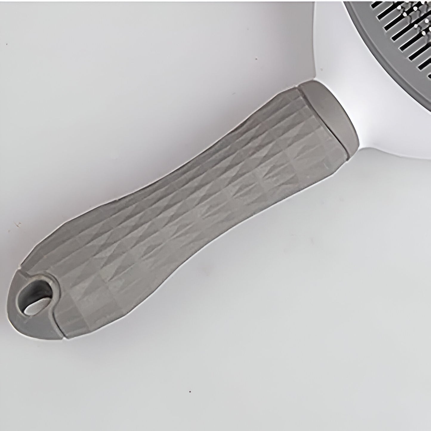 poignée de la brosse pour chien de couleur blanc et gris. Image produit Boutiquechien
