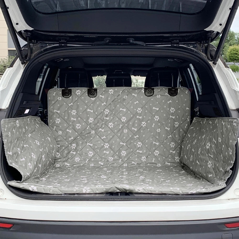 protection de coffre de voiture de couleur noir. La protection est de couleur grise avec des formes de pattes et os dans une voiture de couleur grise. Image produit Boutiquechien