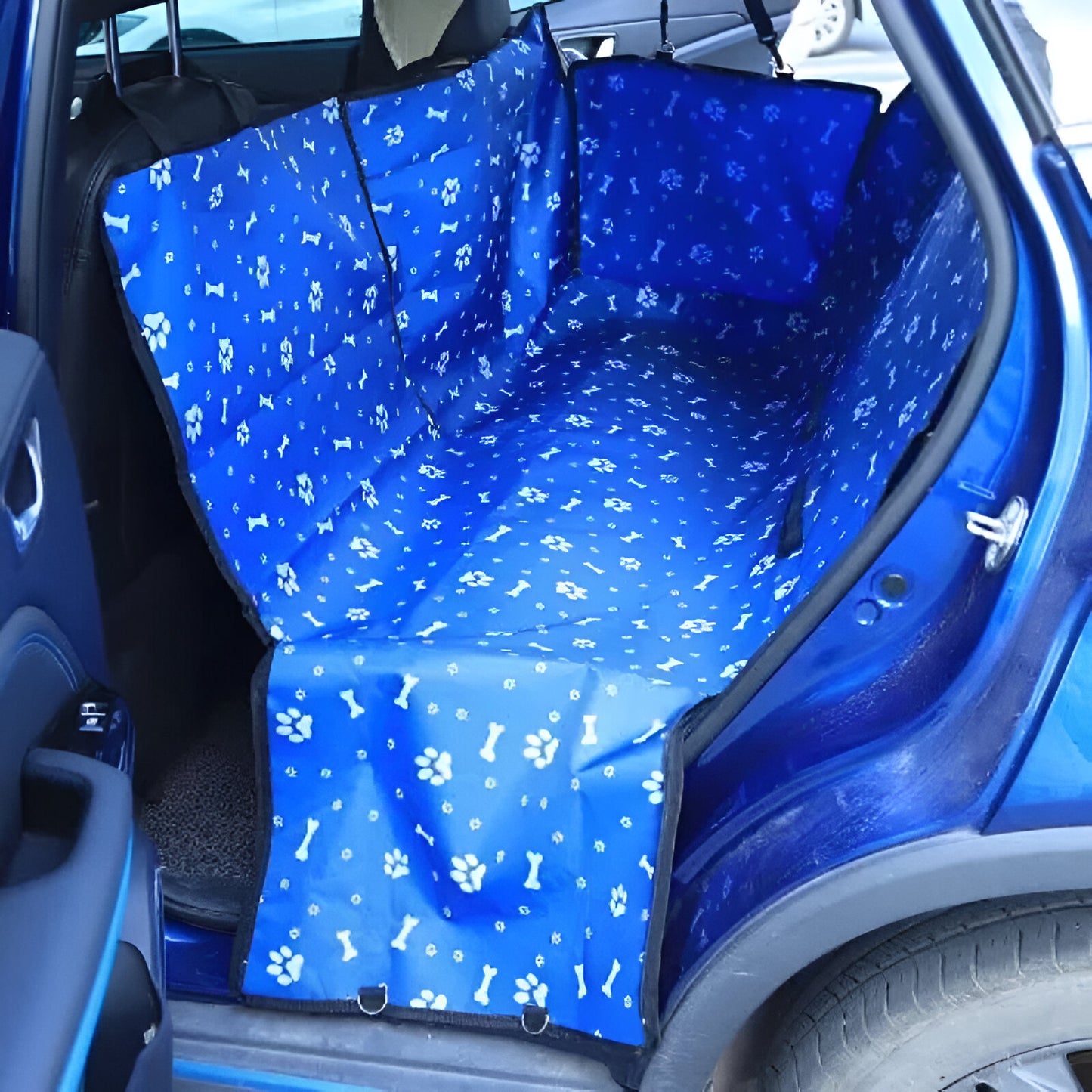protection de siège de couleur bleu avec des motifs blanc de patte et d'os. La protection est dans une voiture de couleur bleu. Image produit Boutiquechien