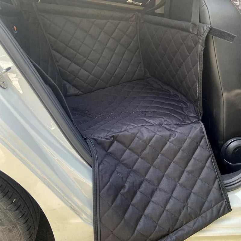 protection de siège pour chien de couleur noir waterproof avec de l'eau dessu. La protection de siège est sur le siège arrière de la voiture une ouverture. Image produit Boutiquechien