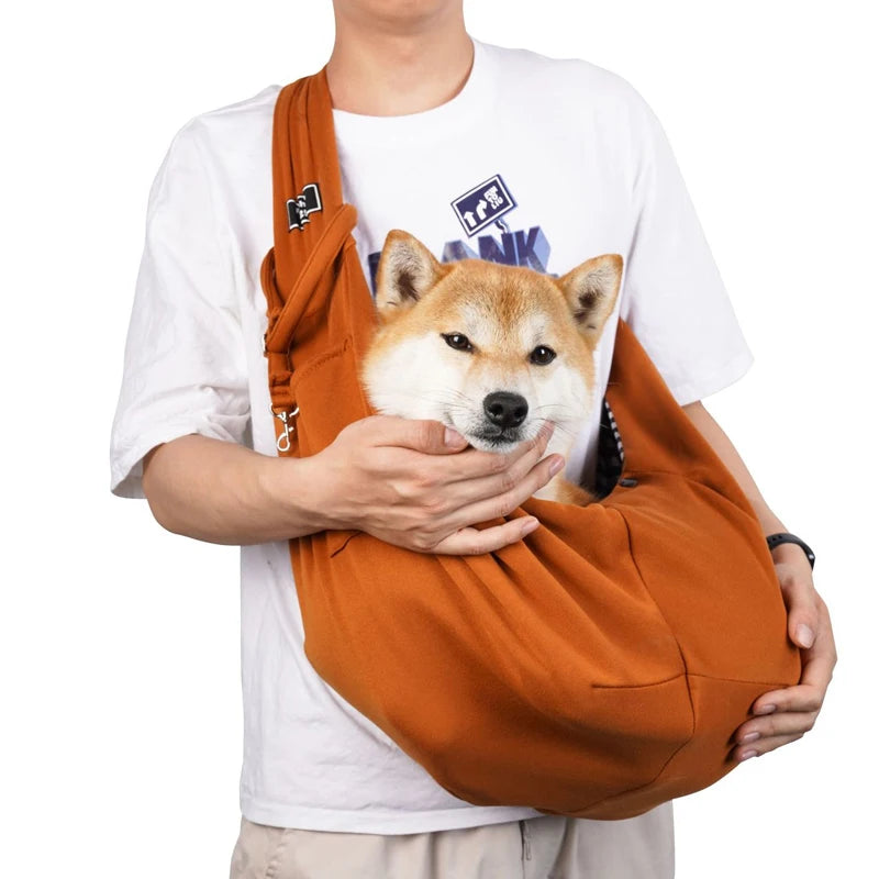 Sac pour chien brun claire porté par un homme habille en blanc avec un short claire. Le sac pour chien est de couleur noir avec une attache dans le sac. Image produit Boutiquechien