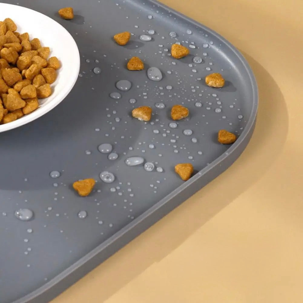 Tapis de protection pour chien de couleur gris avec des croquettes et de l'eau dessus pour montrer la résistance. Image produit Boutiquechien