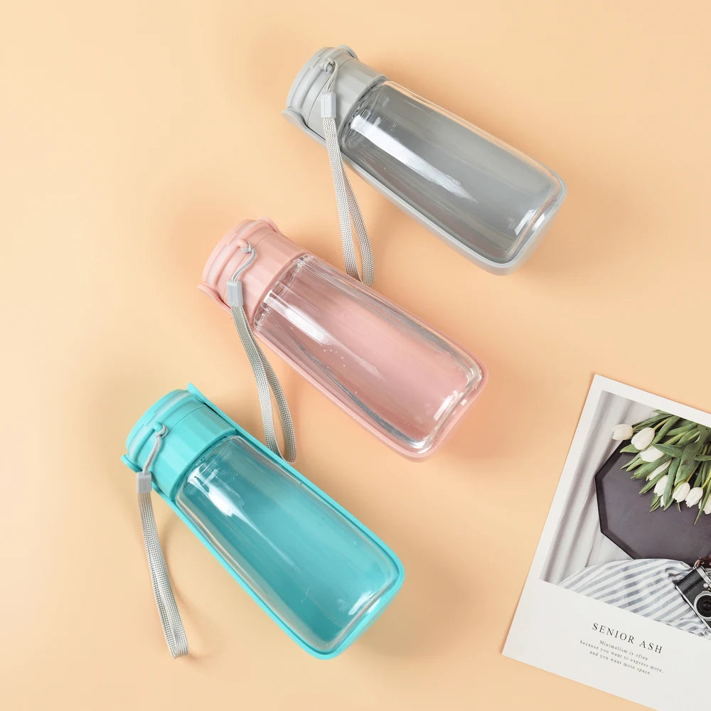 trois gourde d'eau pour chien de couleur vert, abricot et grise posé les unes à côtés des autres. Les produits sont posé dans un fond de couleur orange. Image produit Boutiquechien
