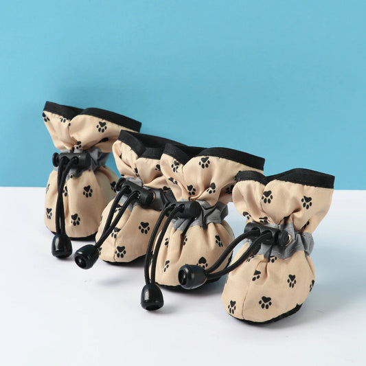 Bottes pour chiens de couleur beige et noir avec des formes de pattes. Les bottes sont ajustable facilement. Image produit Boutiquechien