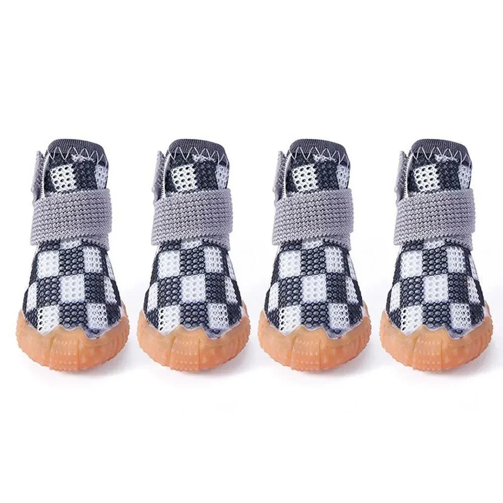 Chaussures pour petits chiens de couleur noir et blanche posé sur une table blanche. image produit Boutiquechien
