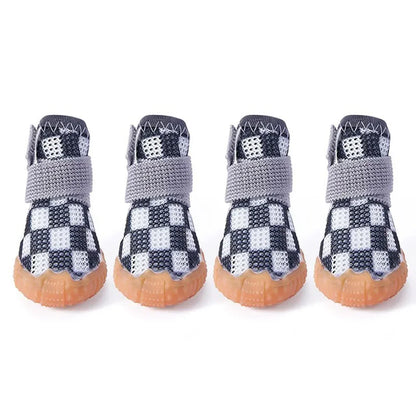 Chaussures pour petits chiens de couleur noir et blanche posé sur une table blanche. image produit Boutiquechien