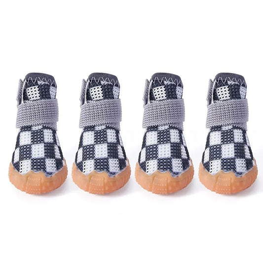 Chaussures pour petits chiens de couleur noir et blanche posé sur une table blanche. image produit Boutiquechien