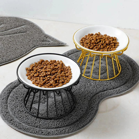 Gamelle pour chien noir et or avec une gamelle céramique blanche sur un tapis de boutiquechien 