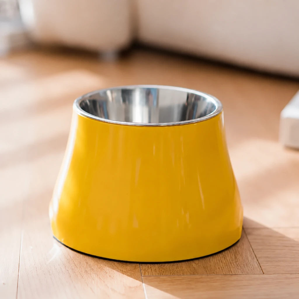 Gamelle pour cocker en inox de couleur jaune sur un parquet en bois dans un salon clair 