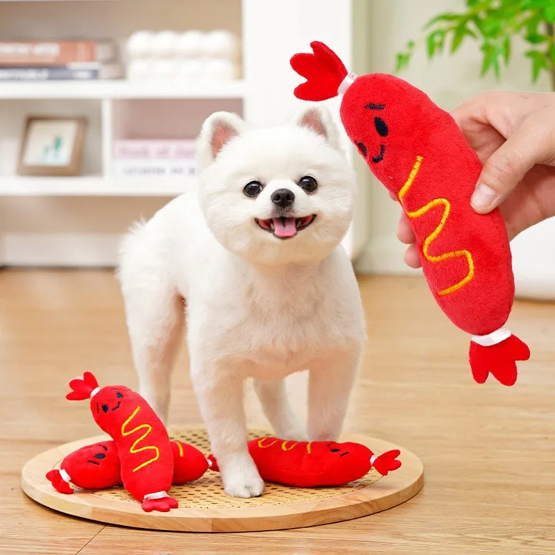 Jouet pour chiot 1 mois en forme de saucisse rouge mis en valeur vers un chien blanc Image