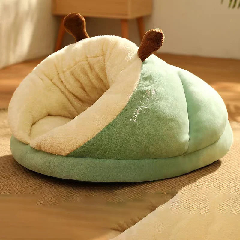 Panier pour chien en forme de nid de couleur vert et blanc avec des oreilles brune. Le panier chien est posé dans un salon de couleur claire avec en fond un meuble en bois. Image produit Boutiquechien