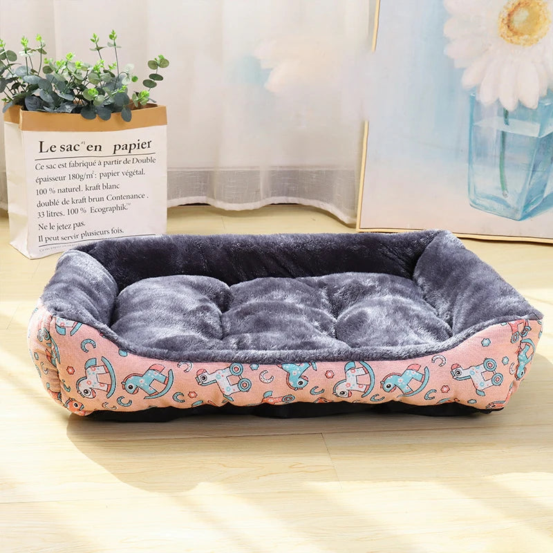 Panier pour chien avec motif licorne dessus posé par terre à côté d'un tableau et d'un sac avec une plante verte dedans. Le panier à des licornes à bascules dessus 
