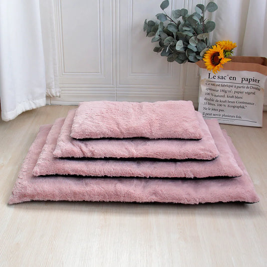 Tapis doux pour chien de couleur rose posé les uns sur les autres. En fond il y a un mur blanc et une plante verte. Image produit Boutiquechien