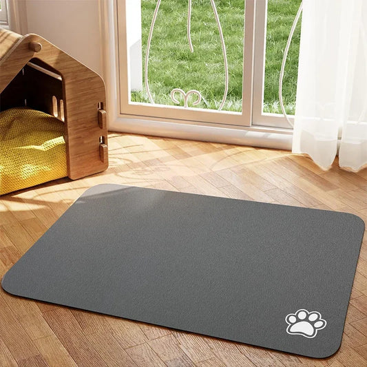 Tapis chien de couleur gris avec une patte de couleur blanche sur le tapis pour gamelle de chien. Le tapis à gamelle pour chien est posé dans un salon avec sur le côté une niche en bois. Image produit Boutiquechien