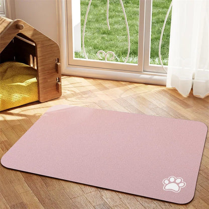 Tapis chien de couleur rose claire avec une patte de couleur blanche sur le tapis pour gamelle de chien. Le tapis à gamelle pour chien est posé dans un salon avec sur le côté une niche en bois. Image produit Boutiquechien