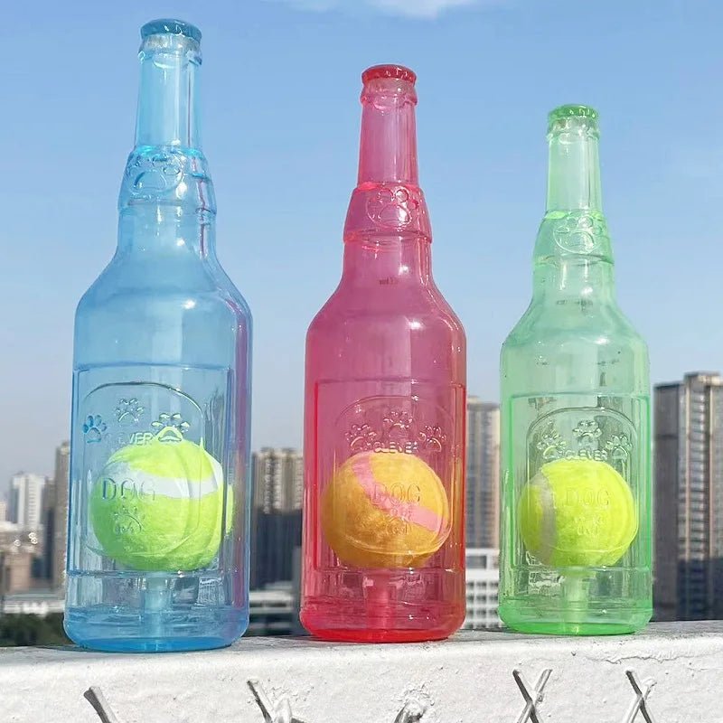 Bouteille bleu, rouge et vert avec une balle de da s pour les chiens qui aiment jouer. Les bouteilles sont devant une grande ville. Image produit Boutiquechein