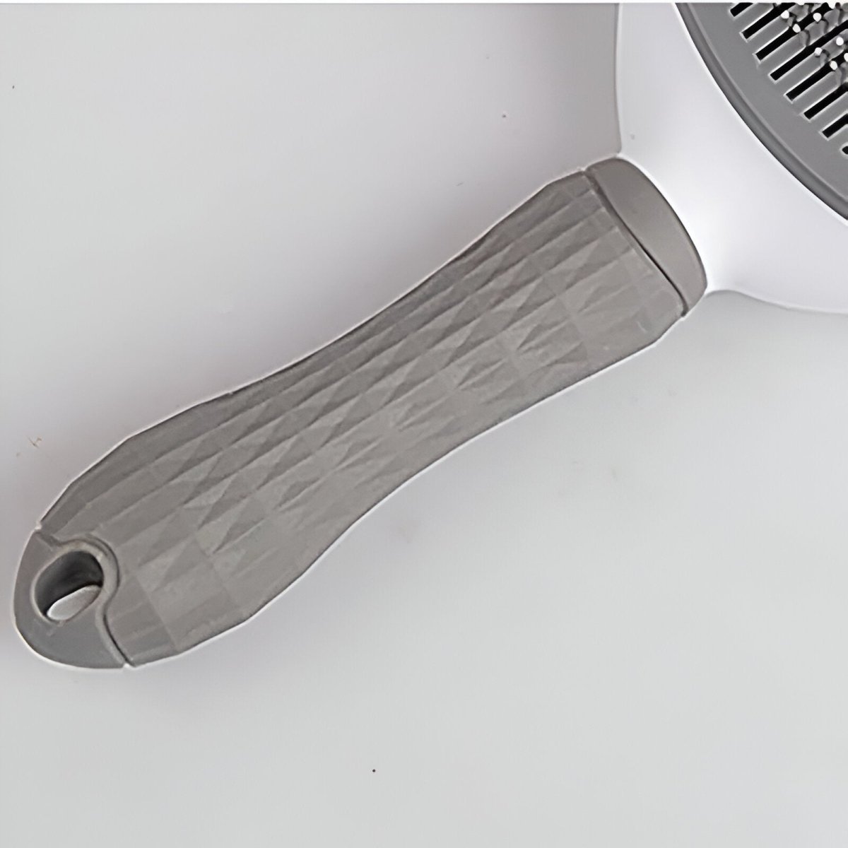 poignée de la brosse pour chien de couleur blanc et gris. Image produit Boutiquechien