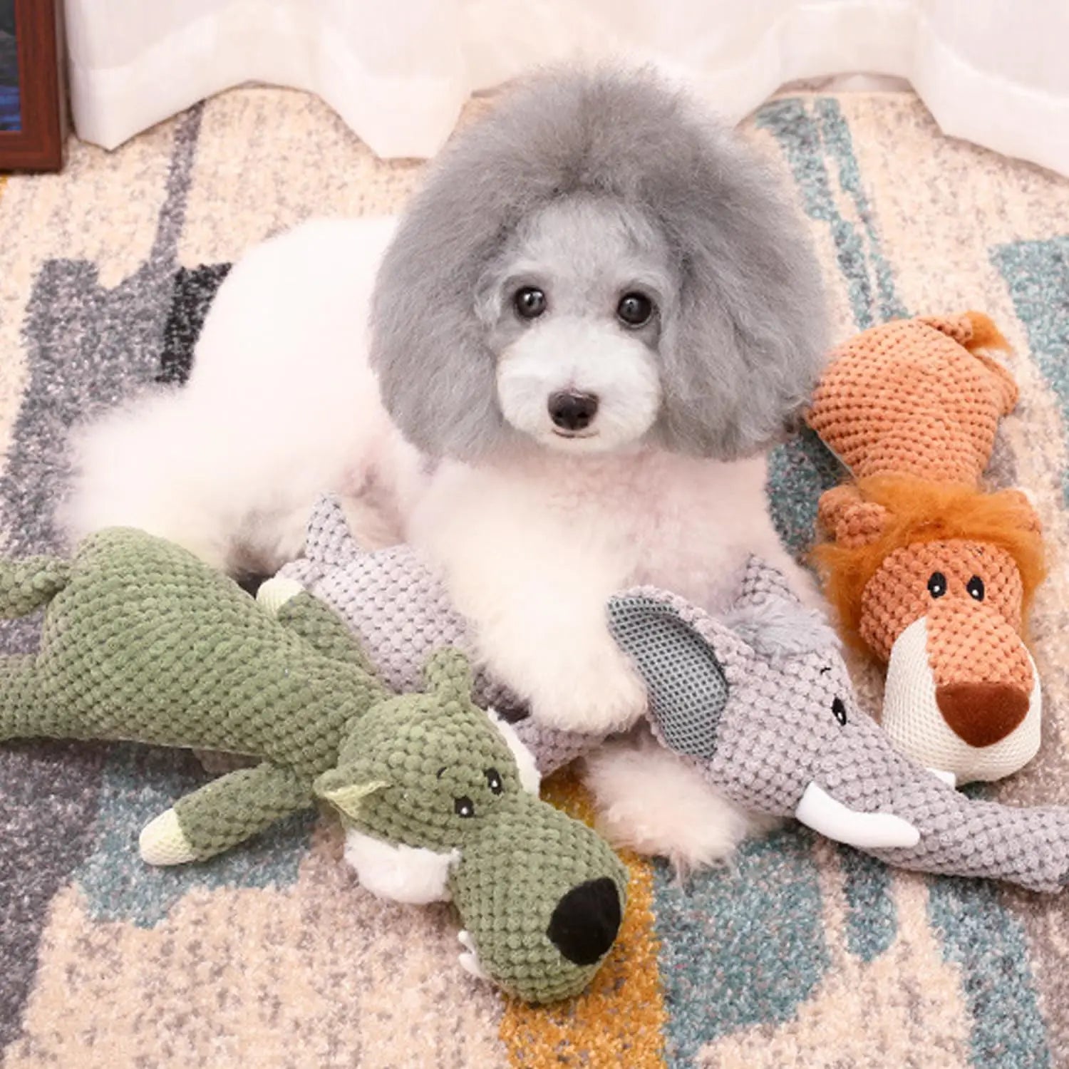 Chien blanc jouant avec ses peluche en formes d'animaux. Image produit Boutiquechien