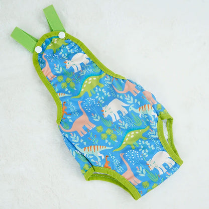 Couche à bretelle pour chien de couleur et vert avec des formes de dinosaures. Le produit est posé dans un fond blanc. Image produit Boutiquechien