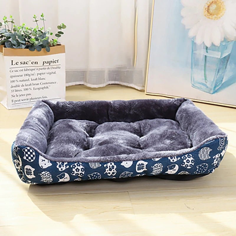 Panier pour chien avec motif chinois dessus de couleurs bleu pour chien. Il est à côté d'un sac avec une plante verte dedans et d'un tableau avec une fleur dessus. L'image sert pour la boutique en ligne boutiquechien 