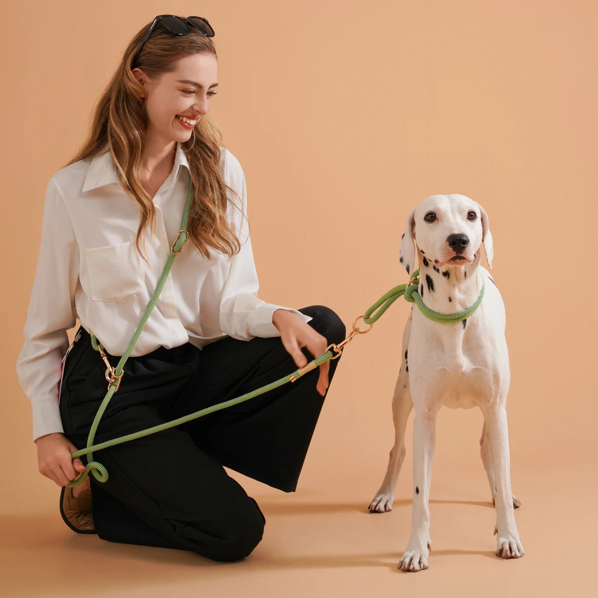 une habillé en noir et blanc tenant une laisse lasso verte avec comme collier pour le chien un Collier chiot beagle vert sur un dalmatien de couleur blanc et noir 