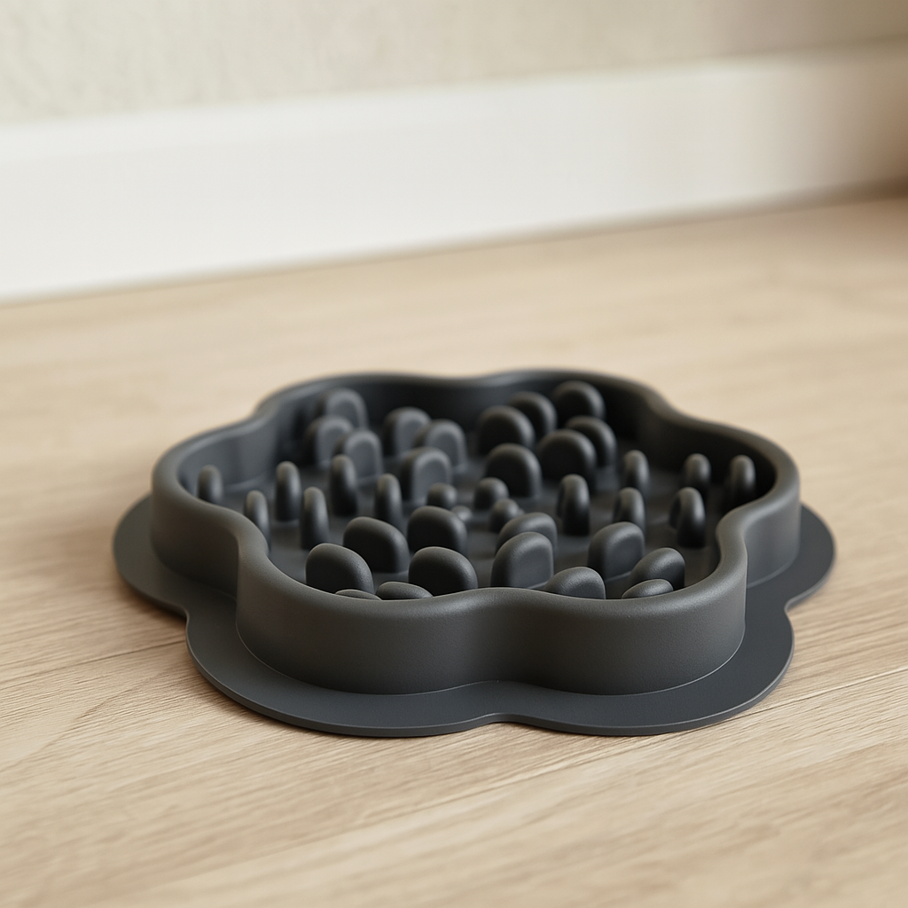 gamelle en silicone de couleur noir posé sur un sol bois avec un fond blanc. Image produit Boutiquechien Image