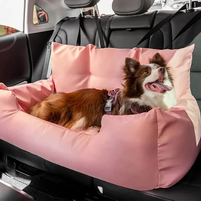 Panier de transport pour chien de couleur rose moelleux pour transport son chien facilement à l'arrière d'une voiture. La protection possède de nombreuses attaches à mettre autour des appuies têtes de voiture de couleur noir Le chien lui est de couleur blanc et brun avec un harnais de couleur rose couché dans tout le panier. Image produit Boutiquechien