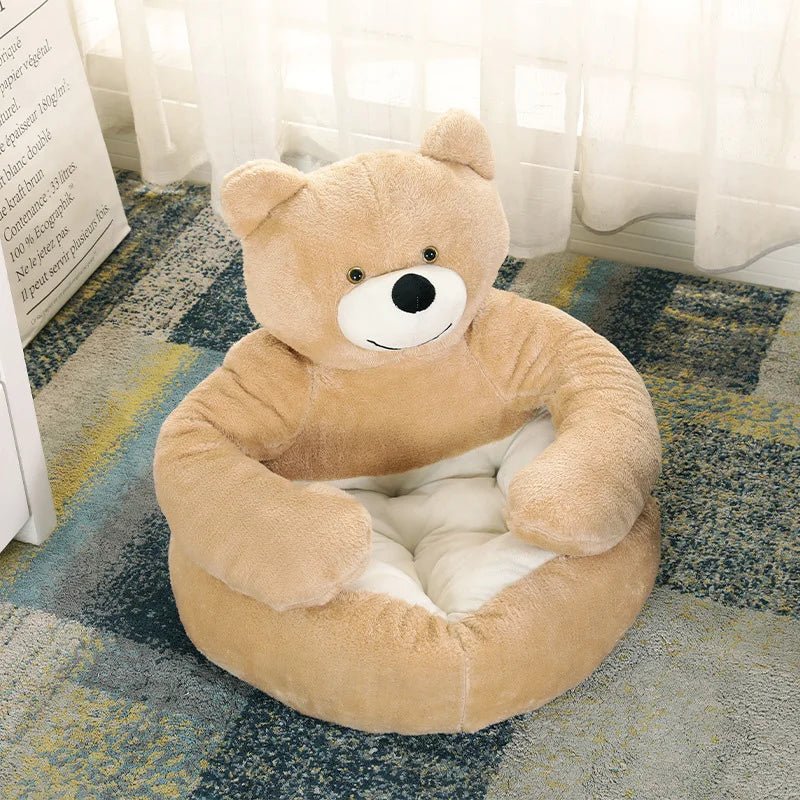 Panier pour chien en forme d'ours de couleur beige avec en fond un canapé bleu. Image produit Boutiquechein 