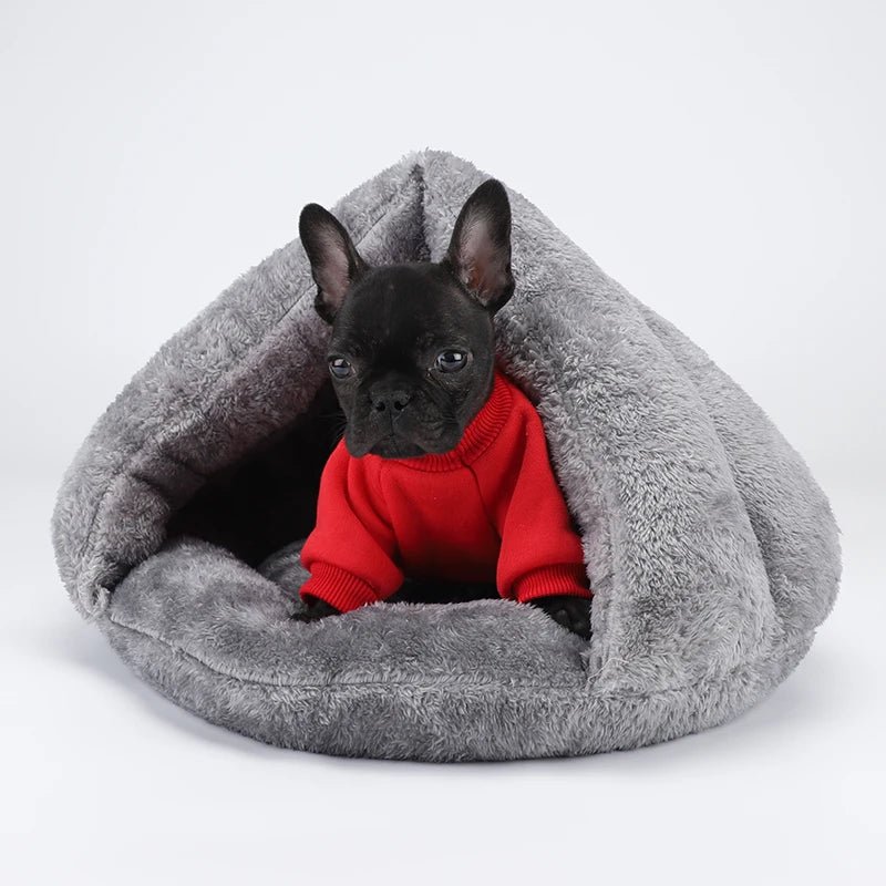 Panier pour petit chien en forme de nid de couleur gris. Le chien est de couleur noir avec un pull de couleur rouge. Le panier chien est durable et résistant. Image produit Boutiquechien 