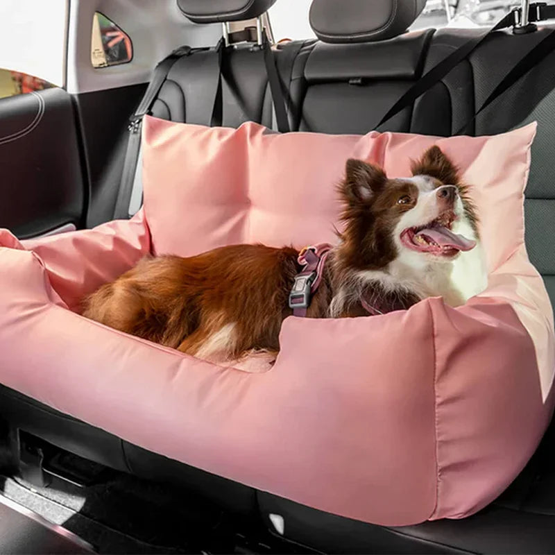 Panier de transport pour chien de couleur rose moelleux pour transport son chien facilement à l'arrière d'une voiture. La protection possède de nombreuses attaches à mettre autour des appuies têtes de voiture de couleur noir Le chien lui est de couleur blanc et brun avec un harnais de couleur rose couché dans tout le panier. Image produit Boutiquechien
