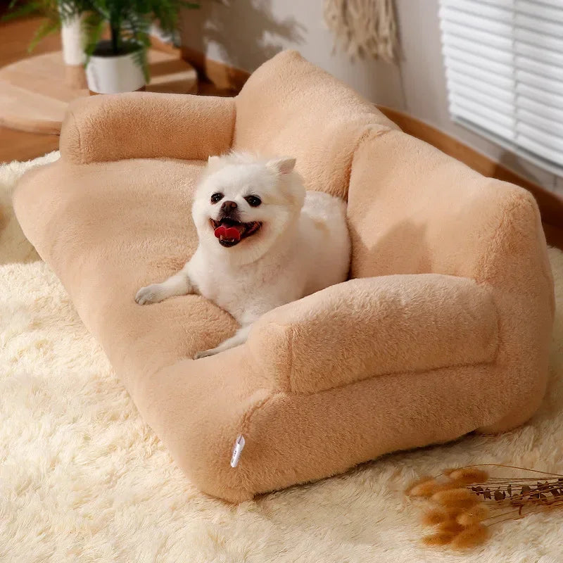 Petit chien blanc couché sur canapé chine doux  et moelleux posé dans un salon de couleur claire. En fond il y a une plante verte. Image produit Boutiquechien Image